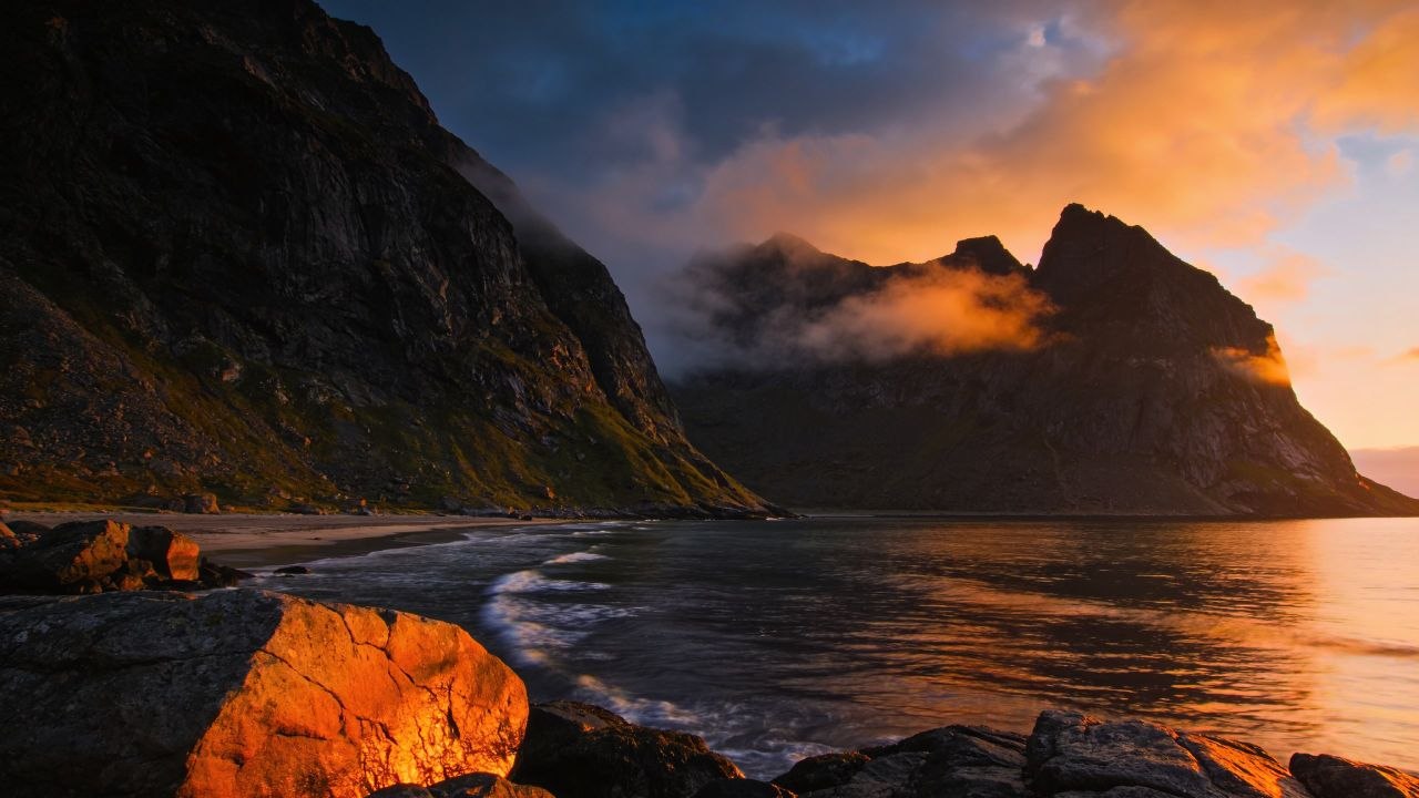 Kustlandschap bij gouden uur — bergen, water en rotsen